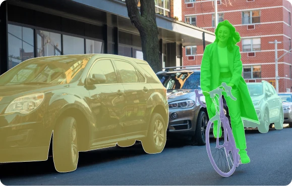 A street scene with semantic segmentation of a car, cyclist, and bicycle, showcasing Objectways' image annotation services.
